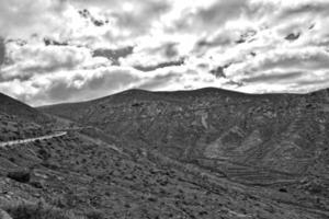 empty mysterious mountainous landscape from the center of the Canary Island Spanish Fuerteventura with a cloudy sky photo