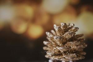 golden christmas cone on the background of bokeh in closeup photo