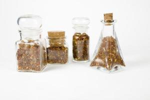 glass containers filled with natural fine ambers on a white background photo