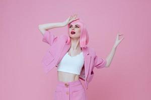 Positive young woman gestures with his hands with a pink jacket Studio Model unaltered photo