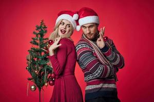 man and woman new year tree decoration holiday red background photo