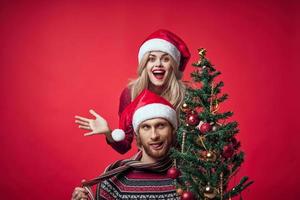 young married couple Christmas tree toys holiday joy red background photo