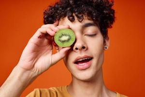 guy with kiwi curly hair near eyes cropped view red background photo