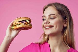 cute cheerful woman in pink shirt hamburger food diet photo