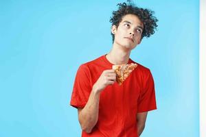gracioso Rizado chico en un rojo camiseta Pizza entrega rápido comida bocadillo foto