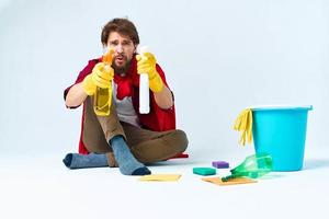 Man on the floor cleaning the house with cleaning supplies photo