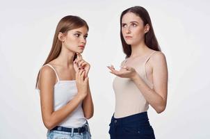 two girlfriends in white t-shirts hugs communication light background photo