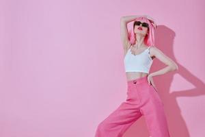 joven mujer en un blanco camiseta y rosado pantalones glamour color antecedentes inalterado foto