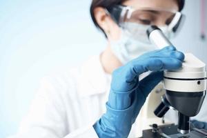 Woman in white coat microscope biotechnology science research photo
