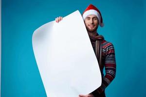 Cheerful man in a santa hat holding a banner holiday isolated background photo