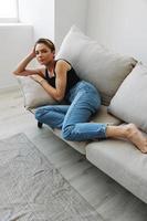 Young woman with short haircut hair having fun at home on the couch smile and happiness, vacation at home, natural posing without filters, free copy space photo