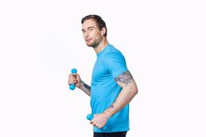 athletic man with dumbbells goes in for sports jogging white background side view photo
