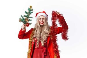 cheerful woman in a Santa costume holding a Christmas tree in her hands photo