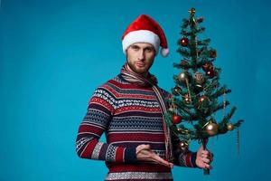 handsome man in a santa hat holding a banner holiday blue background photo