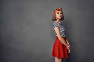 pretty fashionable woman with orange headband red skirt posing photo