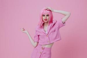 Young positive woman gestures with his hands with a pink jacket pink background unaltered photo
