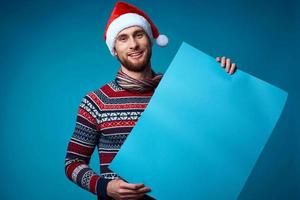 Cheerful man in a santa hat holding a banner holiday studio posing photo