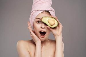 Cheerful woman wearing pink towel on avocado health head photo