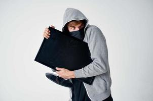 hacker crime anonymity caution balaclava light background photo