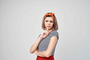 pretty woman with a bandage on her head in a striped t-shirt light background photo