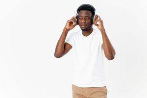 African American in headphones in white t-shirt listening to music photo