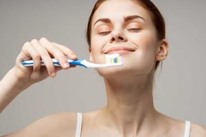 mujer en blanco camiseta limpia dientes higiene estilo de vida foto