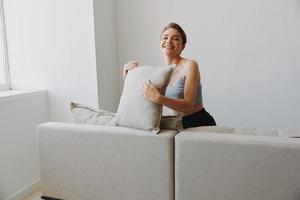 Happy woman smile lying at home on the couch relaxing on a weekend at home with a short haircut hair without filters on a white background, free copy space photo