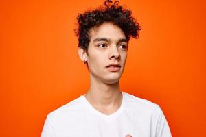 cute guy with curly hair in a white t-shirt close-up photo