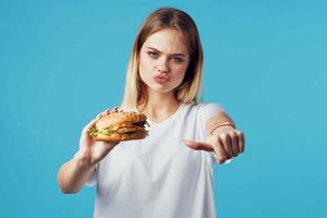 mujer con hamburguesa rápido comida entrega bocadillo divertido azul antecedentes foto