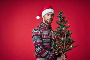 man in christmas clothes christmas tree decoration holiday red background photo