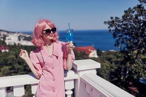 Delighted young girl in sunglasses outdoors on the terrace cocktail relaxing unaltered photo