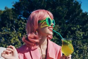 Encantado joven niña con rosado pelo verano cóctel refrescante bebida relajación concepto foto