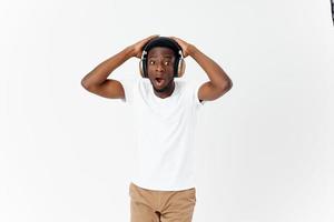 sorprendido hombre en auriculares música gestos con manos emociones ligero antecedentes foto