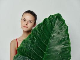 bonito mujer en rojo traje de baño palma hoja zona tropical recortado ver foto