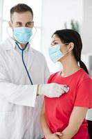 female patient for examination by doctor with stethoscope in hospital photo