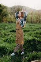 Portrait of a young girl on a summer day in the rays of the setting sun with a beautiful smile, dressed as a farmer and gardener photo