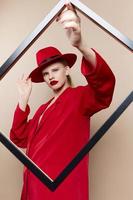 de moda mujer marco en mano en rojo sombrero y chaqueta estilo de vida posando foto