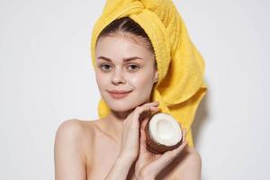 cheerful woman behind an animal with a towel on her head with a coconut in her hands exotic fruits natural cosmetics photo