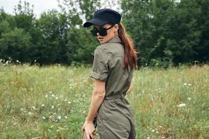 Woman on outdoor Green jumpsuit sunglasses black cap photo