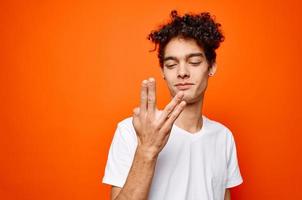 handsome man white t-shirt hand gestures emotions orange background photo