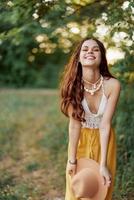 un joven hippie mujer bailando alegremente y sonriente formalmente en naturaleza en el caer. el concepto de económico consumo y cuidados personales foto