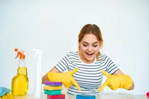 Cleaning lady in rubber gloves sits at the table cleaning tools service lifestyle photo