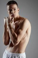 retrato de Boxer con muscular cuerpo en gris antecedentes manos en puño estilo de vida foto