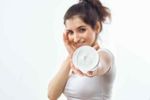 woman in white t-shirt cream jar skin care moisturizing dermatology photo