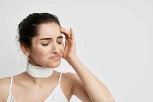 woman bandaged neck negative headache light background photo