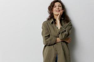 Smiling happy curly beautiful woman in casual khaki green shirt recline on hand looks at camera enjoy cool day posing isolated on over white background. People Emotions Lifestyle concept. Copy space photo