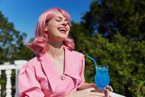 Young female enjoying a colorful cocktail hotel terrace Relaxation concept photo