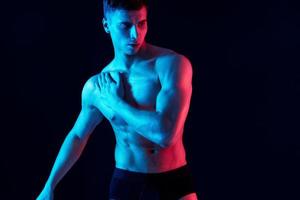 guy with pumped up torso and neon light isolated background photo