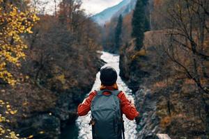 woman tourist stands on the bridge over the river or admires the nature landscape photo