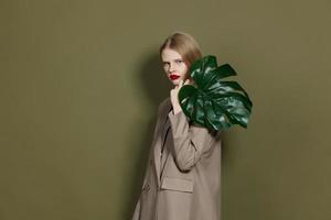 fashionable woman green palm leaf coat bright makeup studio model unaltered photo